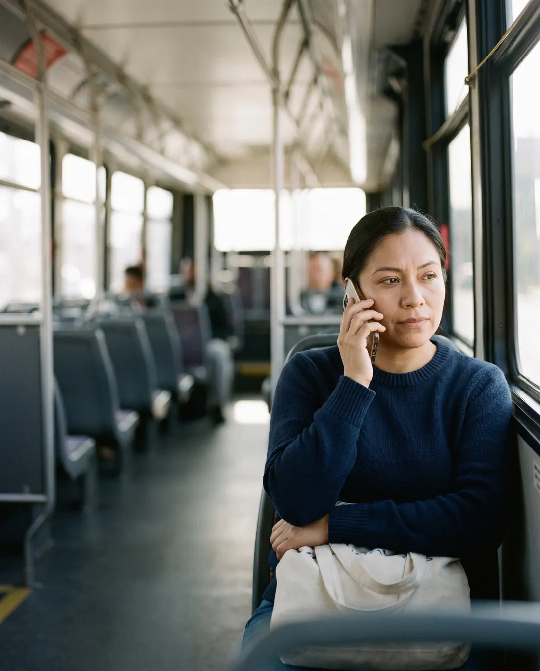 A sales rep taking a call on a city bus